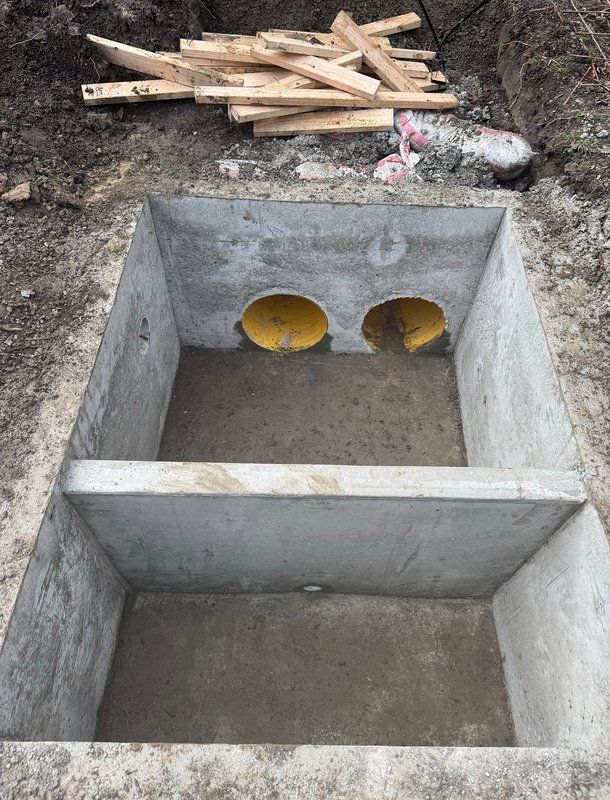 Concrete drainage pit with dual stormwater pipes